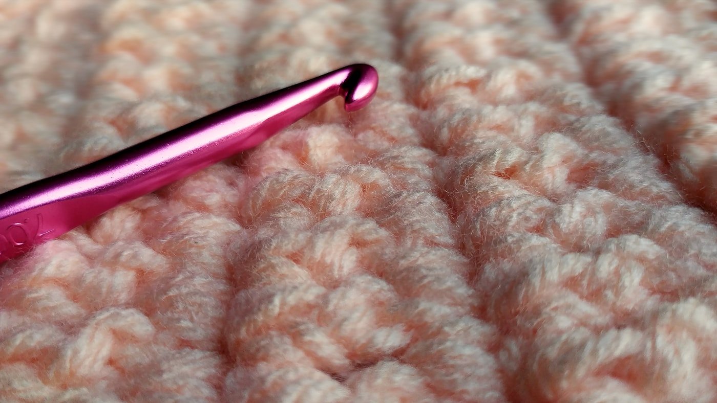 Close-up of a crochet hook showing the hook head and shaft